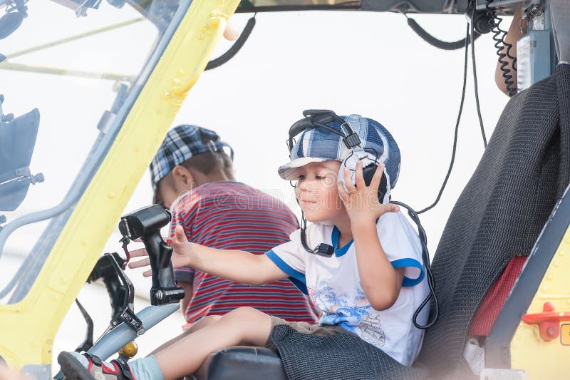 Niño pequeño que se sienta en la cabina del helicóptero MI-8 imagen de archivo libre de regalías Niño pequeño que se sienta en la cabina del helicóptero MI-8 imagen de archivo libre de regalías