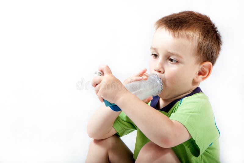 Niño pequeño que usa el inhalador para el asma fotos de archivo libres de regalías Niño pequeño que usa el inhalador para el asma fotos de archivo libres de regalías