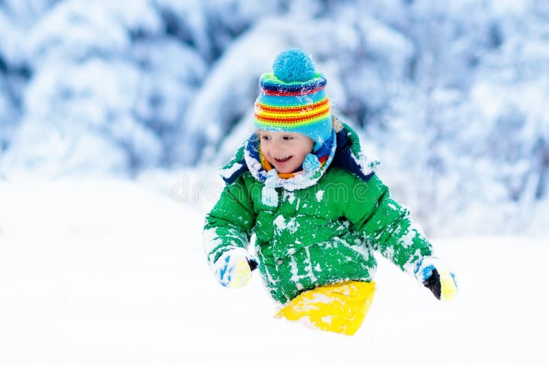 Niño que juega con nieve en invierno Cabritos al aire libre fotos de archivo libres de regalías Niño que juega con nieve en invierno Cabritos al aire libre fotos de archivo libres de regalías