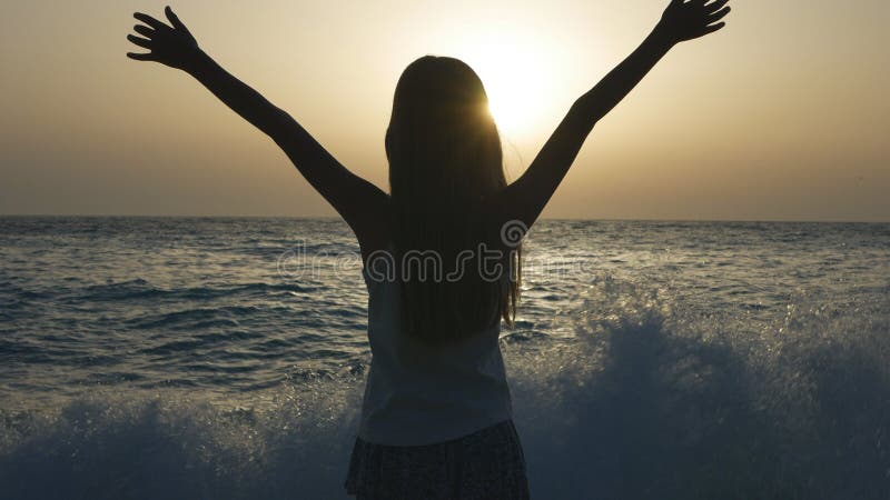 Niño que juega en la playa, niño que considera las ondas la puesta del sol, silueta de la muchacha en la costa fotografía de archivo Niño que juega en la playa, niño que considera las ondas la puesta del sol, silueta de la muchacha en la costa fotografía de archivo