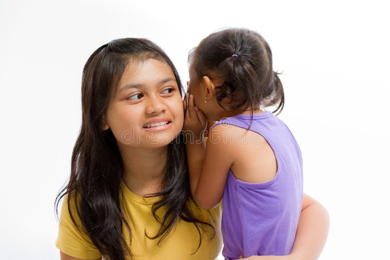 Niño que susurra historia secreta a una más vieja hermana imagen de archivo Niño que susurra historia secreta a una más vieja hermana imagen de archivo