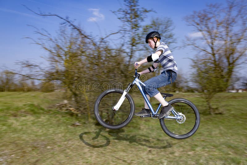 Niño saltando con su bicicleta de tierra fotos de archivo