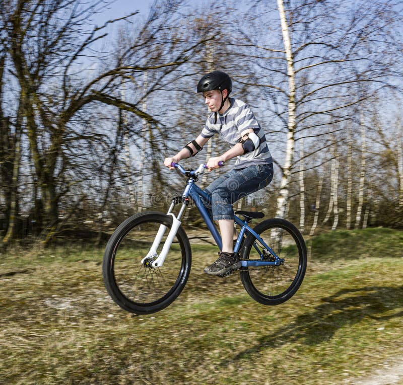 Niño saltando con su bicicleta de tierra imagenes de archivo