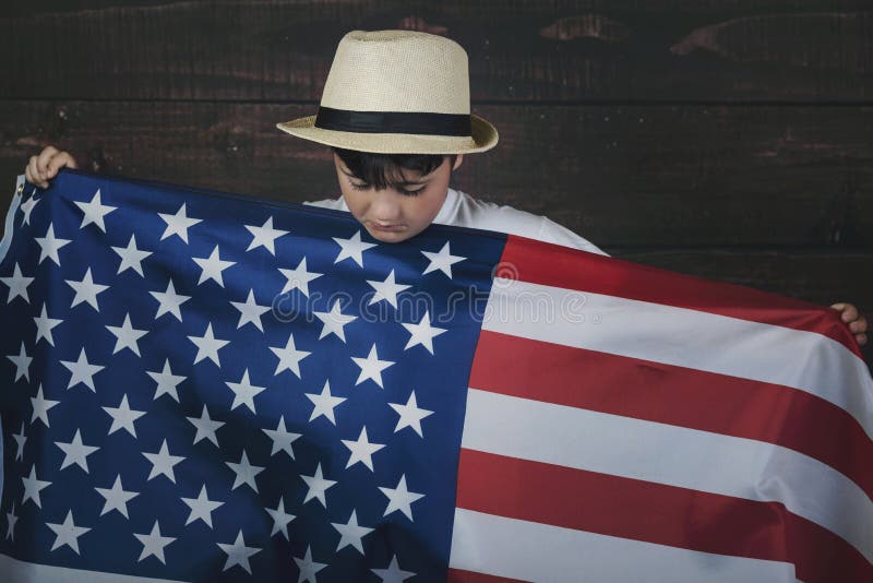 Niño triste con la bandera de los Estados Unidos imagenes de archivo Niño triste con la bandera de los Estados Unidos imagenes de archivo