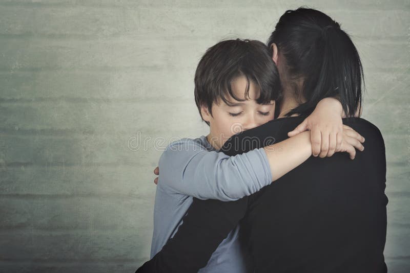 Niño triste que abraza a su madre imágenes de archivo libres de regalías Niño triste que abraza a su madre imágenes de archivo libres de regalías