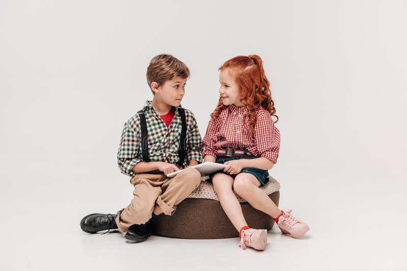 niños adorables que se sonríen mientras que usa la tableta digital fotografía de archivo libre de regalías niños adorables que se sonríen mientras que usa la tableta digital fotografía de archivo libre de regalías