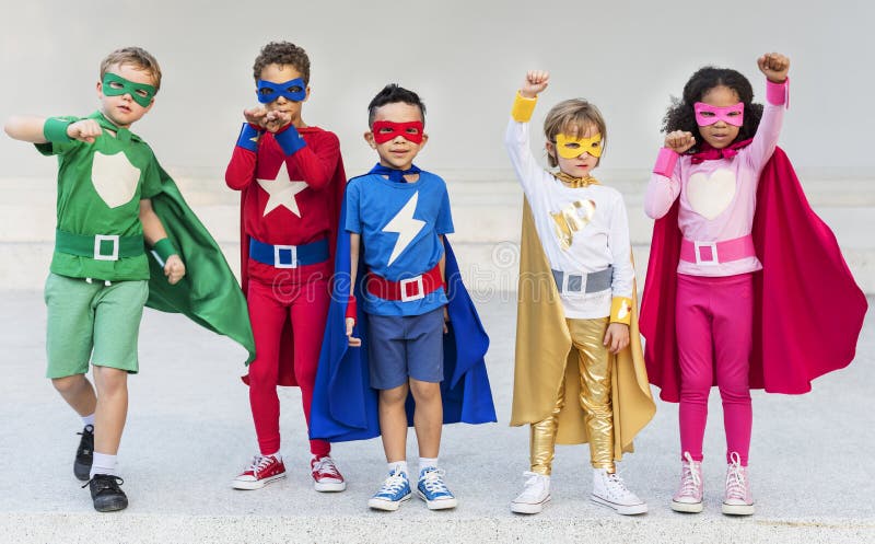 Niños alegres de los super héroes que expresan concepto de la positividad