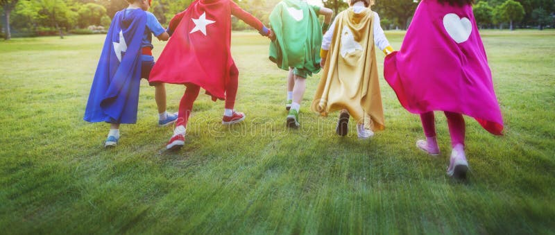 Niños alegres de los super héroes que expresan concepto de la positividad