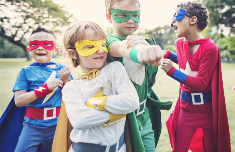 Niños alegres de los super héroes que expresan positividad
