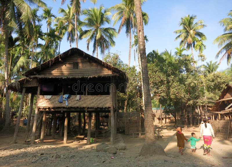Niños birmanos que caminan entre las casas de bambú tradicionales en un pueblo foto de archivo libre de regalías Niños birmanos que caminan entre las casas de bambú tradicionales en un pueblo foto de archivo libre de regalías