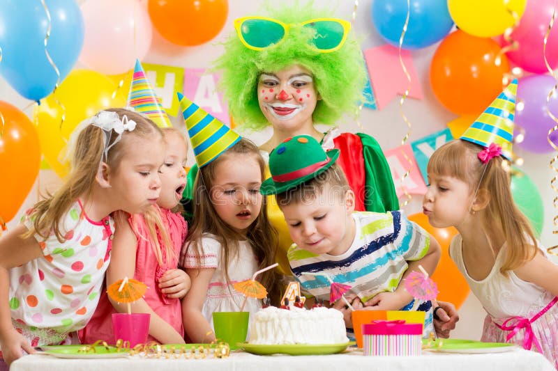 Niños con el payaso que celebra la fiesta de cumpleaños imagen de archivo Niños con el payaso que celebra la fiesta de cumpleaños imagen de archivo