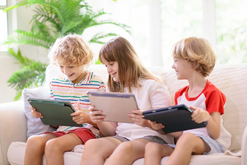 Niños con teléfono móvil. niño con tablet imagenes de archivo