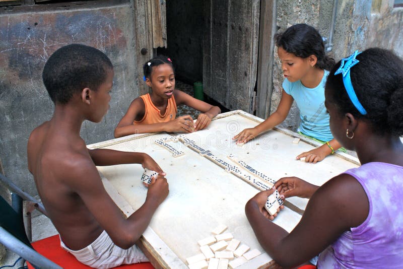 Cuban children playing the favorite cuban board game. They are sitting on a sidewalk; a board serves as table - typical cuban art of improvising. Cuban children playing the favorite cuban board game. They are sitting on a sidewalk; a board serves as table - typical cuban art of improvising.