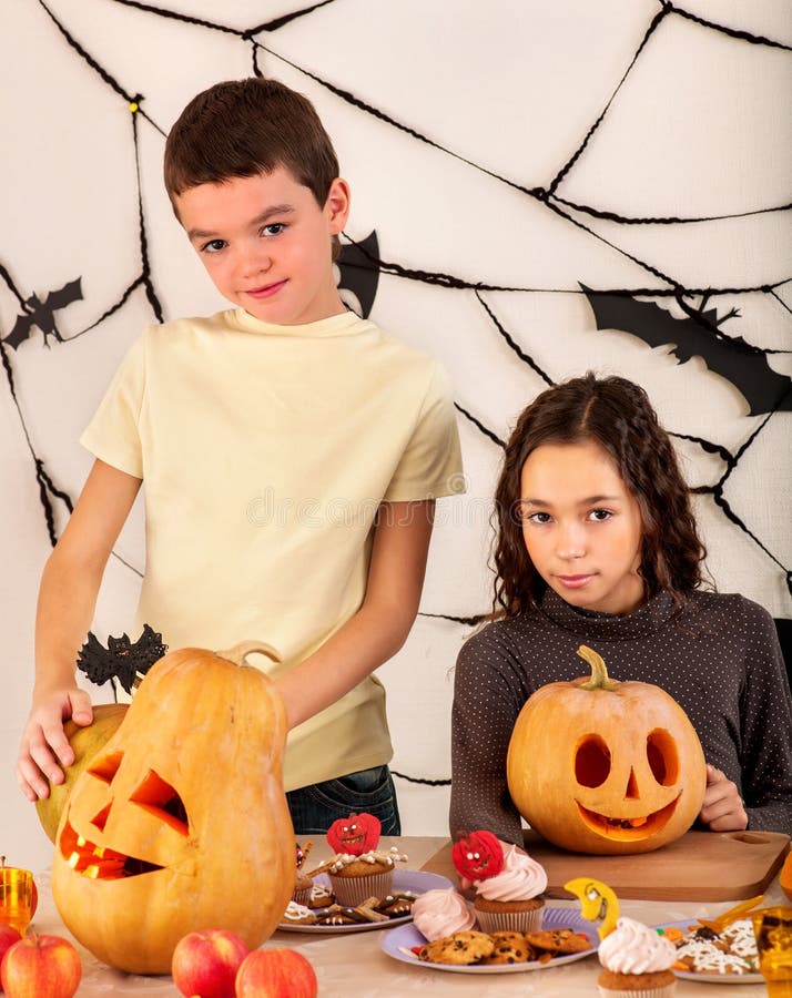 Niños de Halloween que sostienen la calabaza tallada imágenes de archivo libres de regalías Niños de Halloween que sostienen la calabaza tallada imágenes de archivo libres de regalías