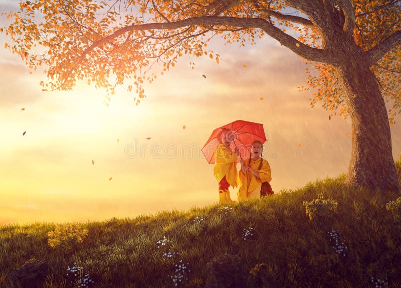 Niños debajo de la ducha del otoño fotografía de archivo Niños debajo de la ducha del otoño fotografía de archivo