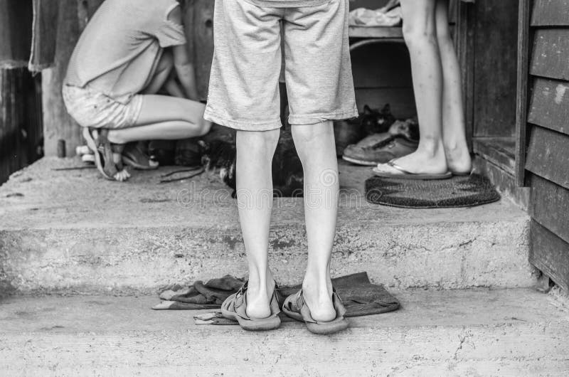 Niños en la foto blanco y negro del pueblo Los pies de los niños en sandalias fotos de archivo Niños en la foto blanco y negro del pueblo Los pies de los niños en sandalias fotos de archivo