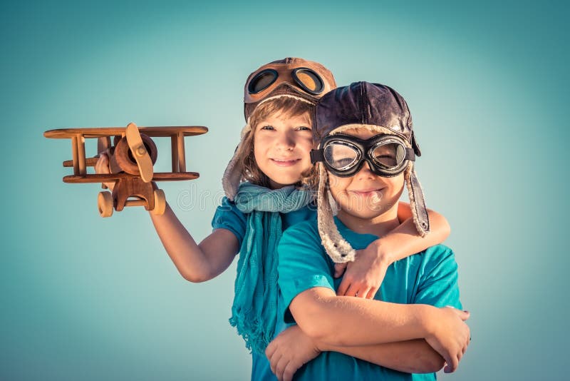 Niños felices que juegan con el aeroplano del juguete
