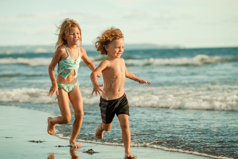 Niños felices que juegan en la playa imagen de archivo Niños felices que juegan en la playa imagen de archivo