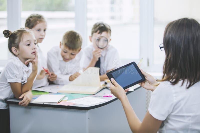 Niños hermosos, los estudiantes y profesor junto en una clase fotos de archivo Niños hermosos, los estudiantes y profesor junto en una clase fotos de archivo