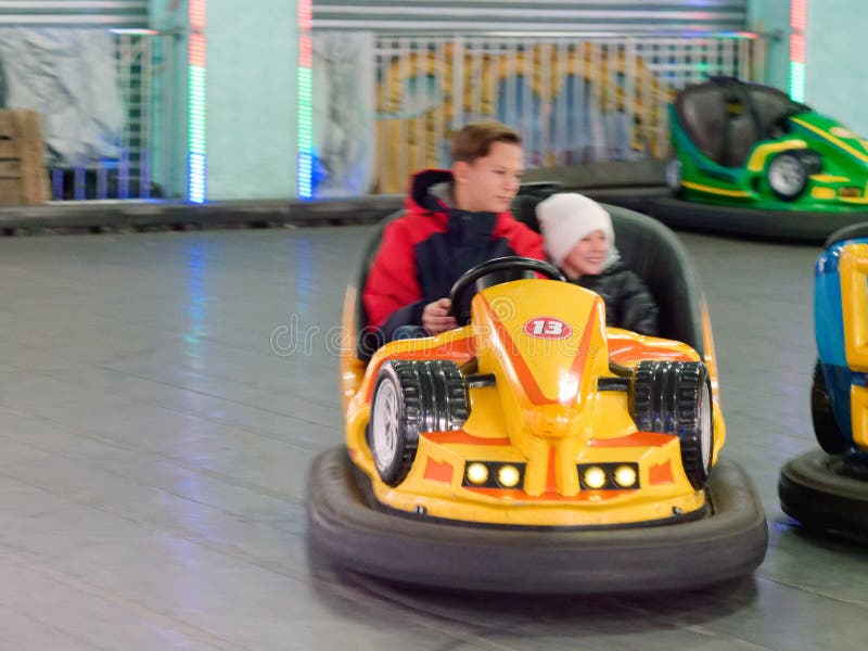 Niños montan coches eléctricos de entretenimiento infantil fotos de archivo Niños montan coches eléctricos de entretenimiento infantil fotos de archivo