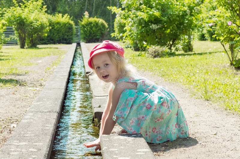 Niños Niña que juega con agua en una cala en un día soleado caliente fotografía de archivo Niños Niña que juega con agua en una cala en un día soleado caliente fotografía de archivo