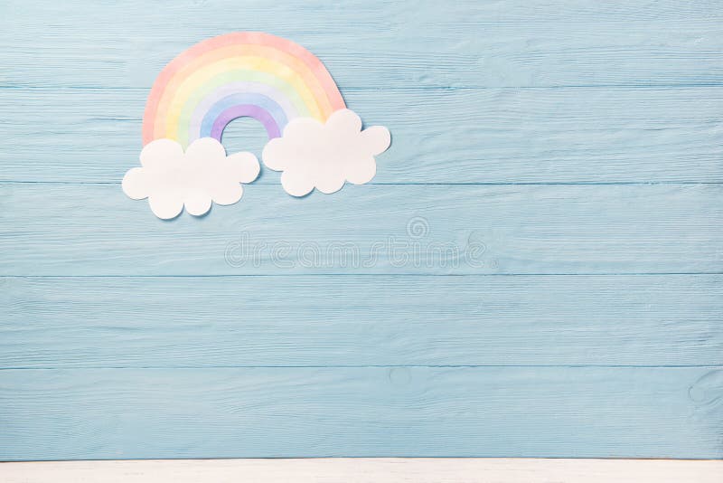 Niños o fondo de bebé, nubes blancas con arco iris sobre fondo de madera azul imágenes de archivo libres de regalías Niños o fondo de bebé, nubes blancas con arco iris sobre fondo de madera azul imágenes de archivo libres de regalías