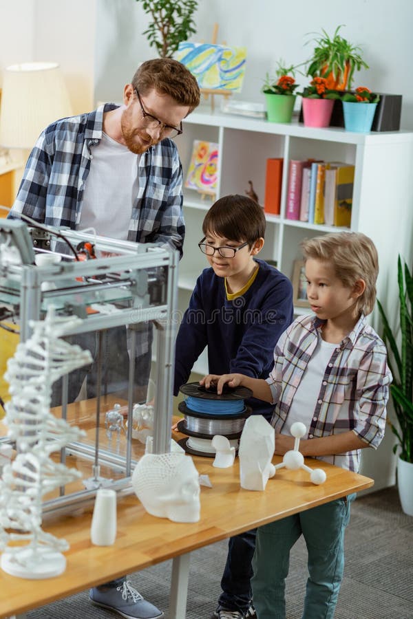 Niños pequeños curiosos que se colocan en laboratorio y que observan el aparato foto de archivo Niños pequeños curiosos que se colocan en laboratorio y que observan el aparato foto de archivo