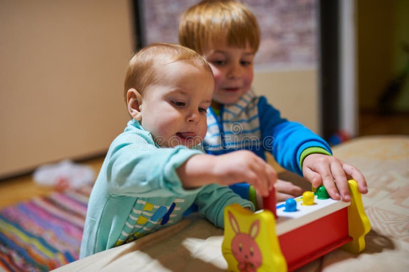 Niños pequeños lindos que juegan con los juguetes por el hogar imágenes de archivo libres de regalías Niños pequeños lindos que juegan con los juguetes por el hogar imágenes de archivo libres de regalías