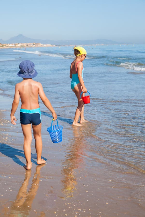Niños que buscan cáscaras del mar fotografía de archivo libre de regalías Niños que buscan cáscaras del mar fotografía de archivo libre de regalías