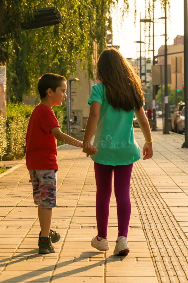 Niños que caminan abajo de la calle que lleva a cabo las manos fotos de archivo Niños que caminan abajo de la calle que lleva a cabo las manos fotos de archivo