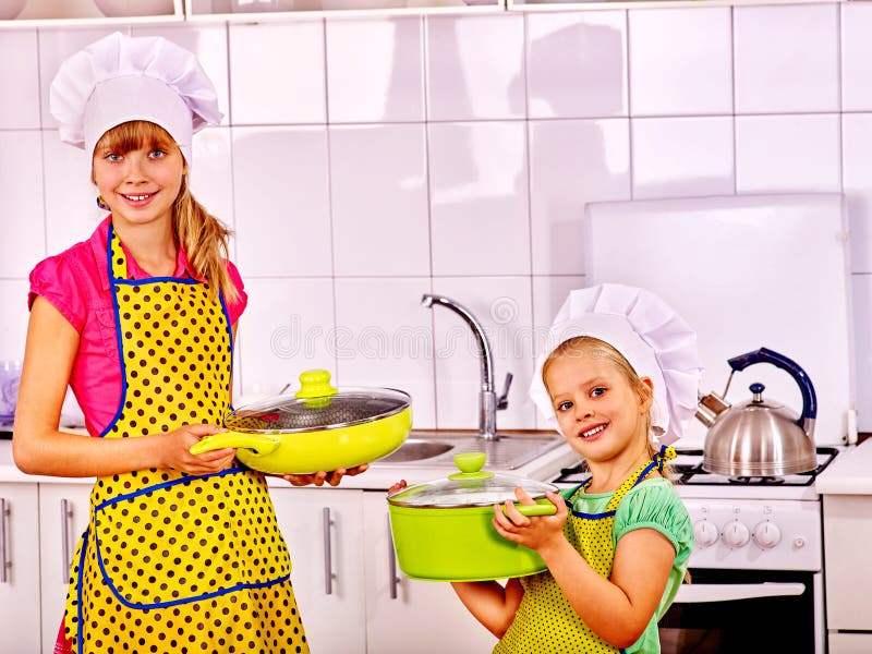 Niños que cocinan en casa la cocina Muchacha en sombrero del cocinero fotos de archivo Niños que cocinan en casa la cocina Muchacha en sombrero del cocinero fotos de archivo