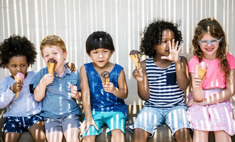 Niños que comen el helado en el verano fotografía de archivo libre de regalías Niños que comen el helado en el verano fotografía de archivo libre de regalías