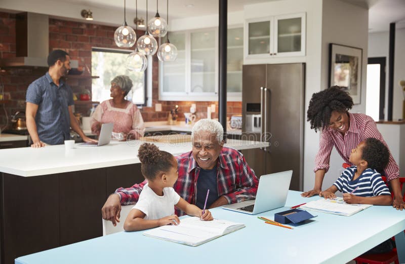 Children Doing Homework In Busy Multi Generation Family Home. Children Doing Homework In Busy Multi Generation Family Home