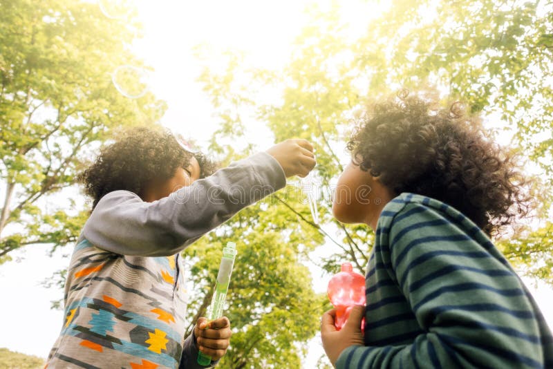 Niños que juegan con los amigos Niños que juegan burbujas que soplan fotografía de archivo libre de regalías Niños que juegan con los amigos Niños que juegan burbujas que soplan fotografía de archivo libre de regalías