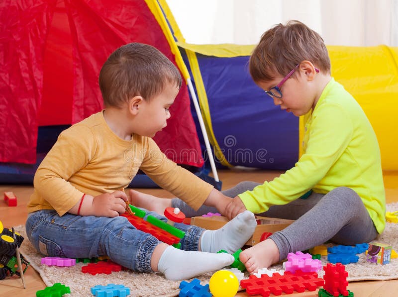 Niños que juegan con los juguetes coloreados fotos de archivo libres de regalías Niños que juegan con los juguetes coloreados fotos de archivo libres de regalías