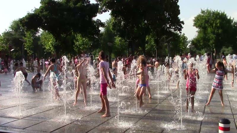 Niños que juegan con los rubores del agua almacen de metraje de vídeo Niños que juegan con los rubores del agua almacen de metraje de vídeo