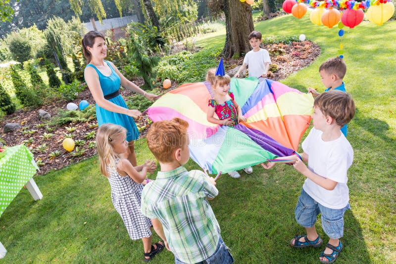 Niños que juegan a juegos del paracaídas