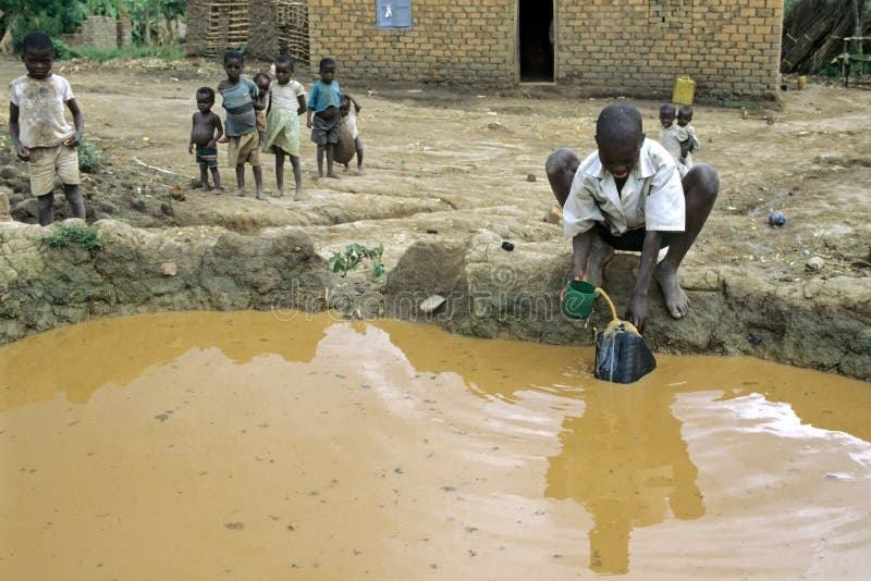 Niños que juegan y agua sucia de la búsqueda del muchacho del pozo