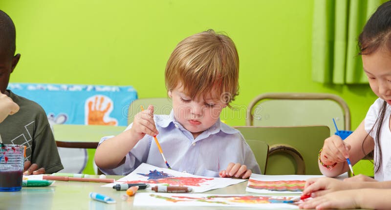 Niños que pintan en guardería imagenes de archivo Niños que pintan en guardería imagenes de archivo