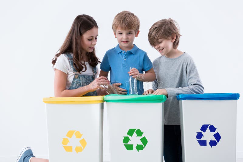 Niños que segregan basura imagen de archivo libre de regalías Niños que segregan basura imagen de archivo libre de regalías