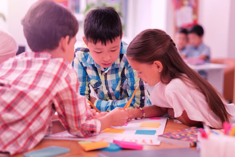 Niños que trabajan en su proyecto de la escuela junto imagenes de archivo Niños que trabajan en su proyecto de la escuela junto imagenes de archivo