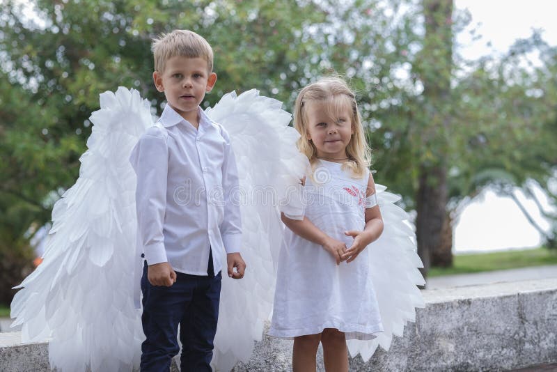 Niños vestidos como ángeles caminan por el parque fotos de archivo libres de regalías