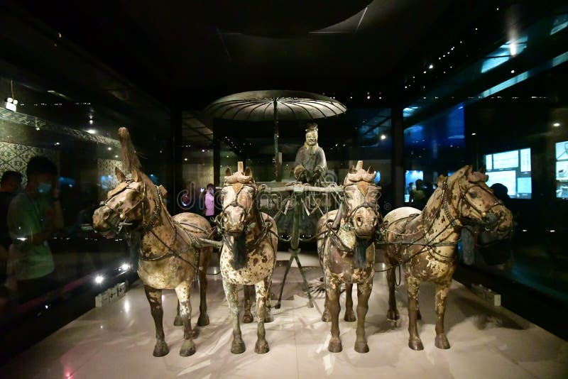 Two large scale models of bronze chariots and horses came unearthed in December, 1980, about 20 meters 22 yards west to the mound of Qin Shi Huang Mausoleum. Tagged Bronze Chariot and Horses No. 1 and No. 2 respectively, they were originally encased in a wooden box which was buried 8 meters 26 feet down in a trench for over two thousand years. No. 1 Chariot is the vanguard. There is a large umbrella providing shade from the sun. Its handle is flexible and rotatable to block the sun from different angles, hence this umbrella is considered to be the world`s earliest sunshade. A driver is standing below the umbrella, with his hands holding the horses’ rein. The entire No. 1 bronze carriage and horses are decorated with exquisite colored drawings, and gold and silver ornaments weighing over 3,000 and 4,000 grams 6.6 and 8.8 pounds respectively. Two large scale models of bronze chariots and horses came unearthed in December, 1980, about 20 meters 22 yards west to the mound of Qin Shi Huang Mausoleum. Tagged Bronze Chariot and Horses No. 1 and No. 2 respectively, they were originally encased in a wooden box which was buried 8 meters 26 feet down in a trench for over two thousand years. No. 1 Chariot is the vanguard. There is a large umbrella providing shade from the sun. Its handle is flexible and rotatable to block the sun from different angles, hence this umbrella is considered to be the world`s earliest sunshade. A driver is standing below the umbrella, with his hands holding the horses’ rein. The entire No. 1 bronze carriage and horses are decorated with exquisite colored drawings, and gold and silver ornaments weighing over 3,000 and 4,000 grams 6.6 and 8.8 pounds respectively.