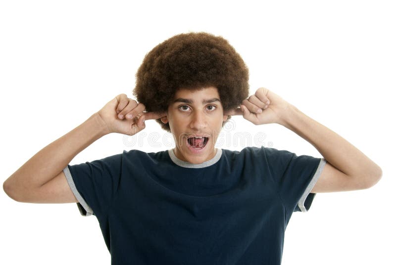 Mixed-race teenage boy with her fingers in his ears making noises. Mixed-race teenage boy with her fingers in his ears making noises