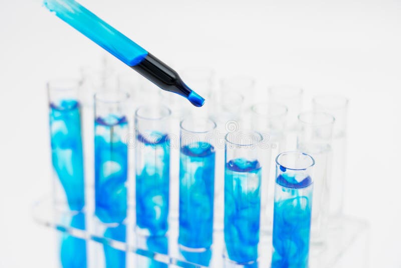 No laboratório, os cientistas sintetizaram e analisaram o composto deixando cair o líquido colorido em uns tubos de ensaio Fundo fotos de stock No laboratório, os cientistas sintetizaram e analisaram o composto deixando cair o líquido colorido em uns tubos de ensaio Fundo fotos de stock