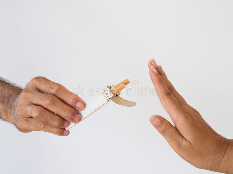 No smoking. Close up of male hands holding cigarettes and proposing it to person. The human arm is gesturing with refusal on whit royalty free stock photo No smoking. Close up of male hands holding cigarettes and proposing it to person. The human arm is gesturing with refusal on whit royalty free stock photo