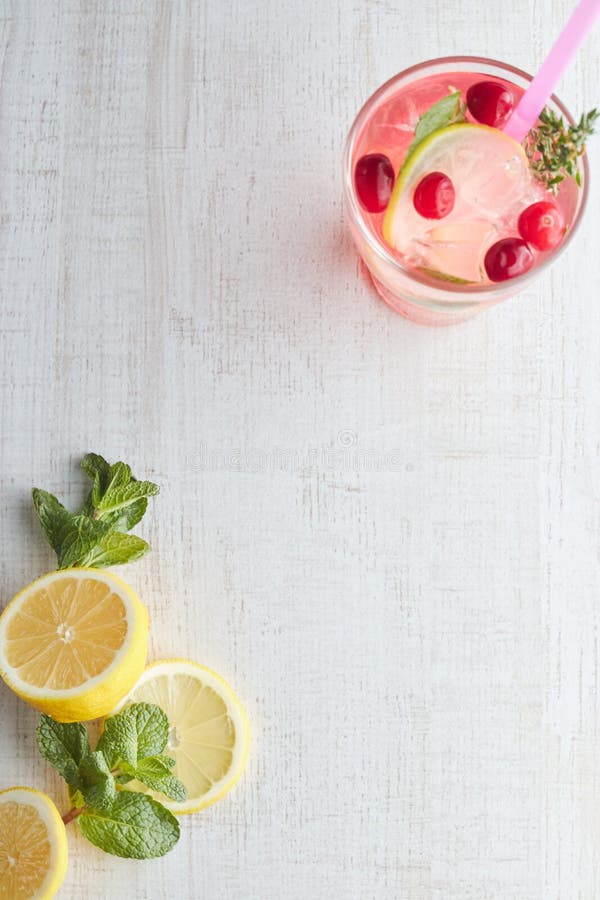 No verão, no cocktail da limonada da baga da bebida com limão e no gelo em um vidro Limonada Ice-cold Bebida saudável da vitamina foto de stock No verão, no cocktail da limonada da baga da bebida com limão e no gelo em um vidro Limonada Ice-cold Bebida saudável da vitamina foto de stock