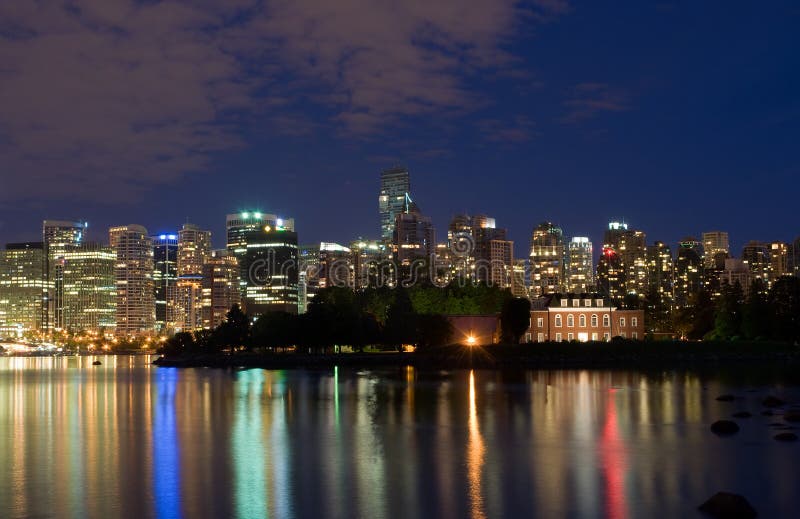 A nighttime panoramic view of the waterfront and skyline of Vancouver, British Columbia, Canada. A nighttime panoramic view of the waterfront and skyline of Vancouver, British Columbia, Canada.