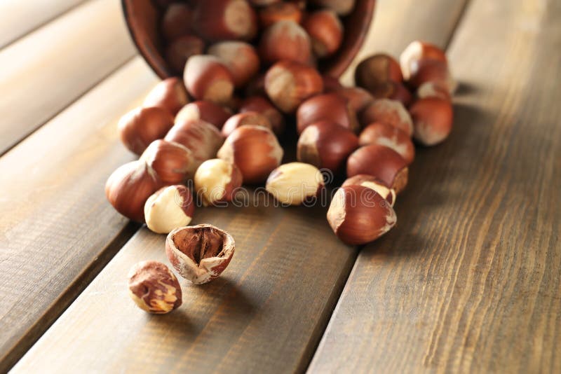 Nocciole sparse sulla tavola di legno immagine stock Nocciole sparse sulla tavola di legno immagine stock