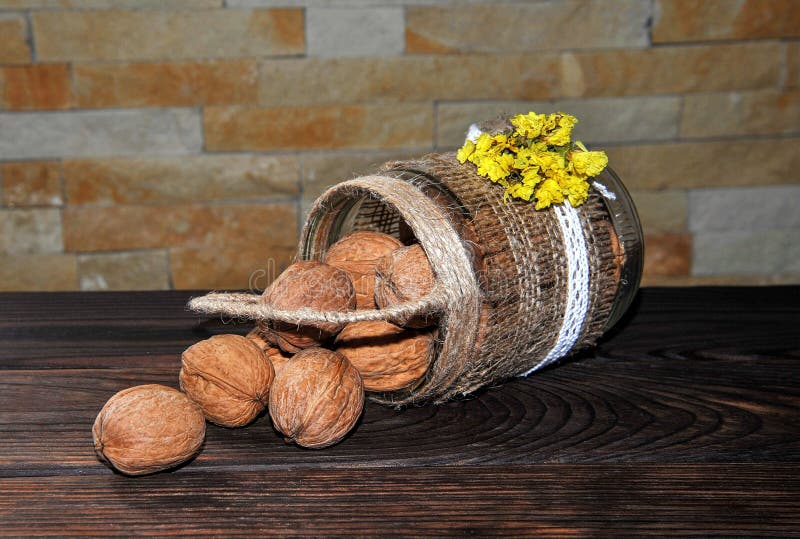 Noci non sbucciate in una latta sotto forma di canestro su una tavola di legno immagine stock Noci non sbucciate in una latta sotto forma di canestro su una tavola di legno immagine stock